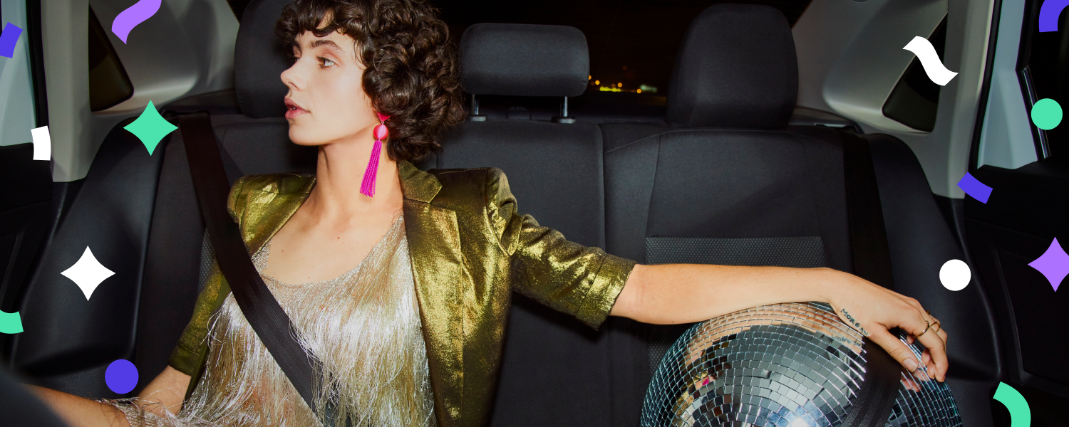 Woman dressed up for New Years celebration in her Lyft ride with a disco ball seatbelted next to her